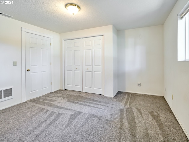 unfurnished bedroom with carpet and a textured ceiling