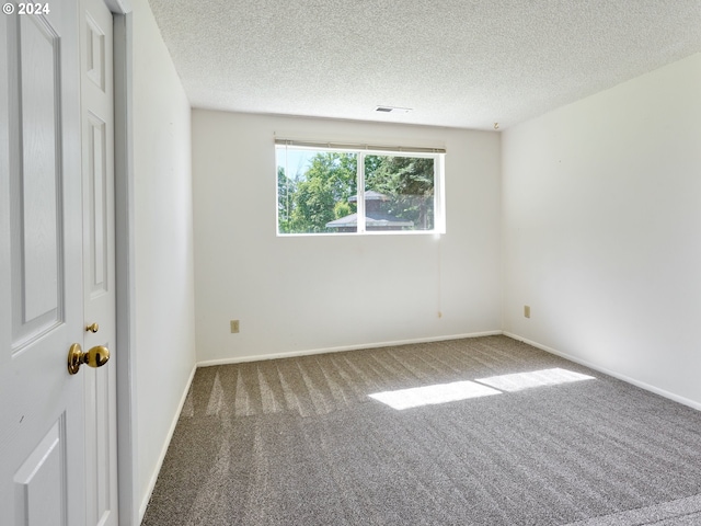 carpeted spare room featuring a textured ceiling