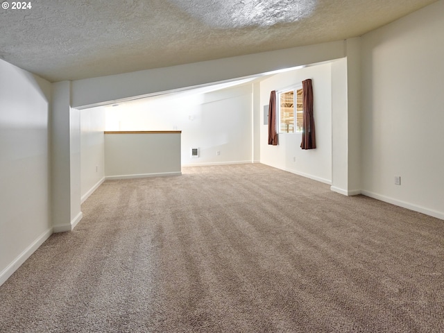 carpeted empty room featuring a textured ceiling