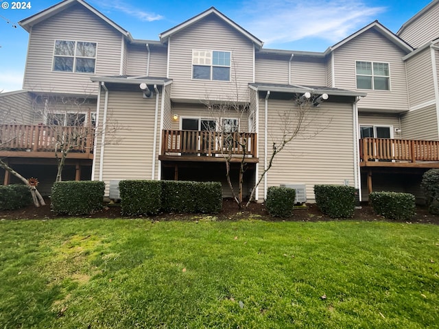 rear view of house featuring a deck and a lawn