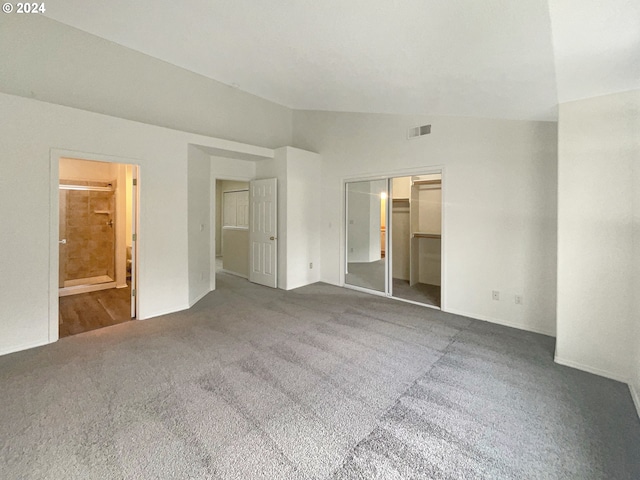 carpeted empty room with lofted ceiling