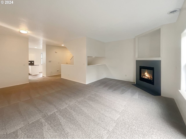 unfurnished living room featuring dark carpet