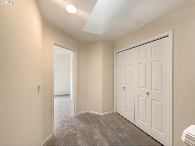 hall with dark colored carpet