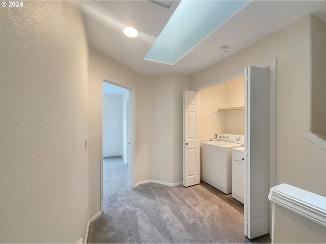 laundry room featuring light carpet and separate washer and dryer