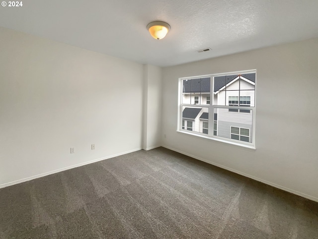 carpeted empty room with a textured ceiling