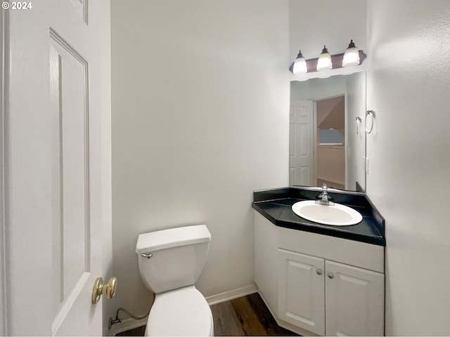 bathroom with oversized vanity, toilet, and hardwood / wood-style flooring