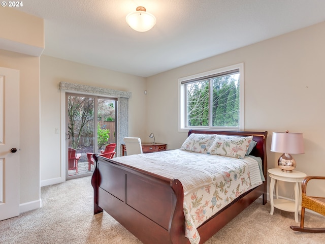 bedroom with access to exterior, light colored carpet, and multiple windows