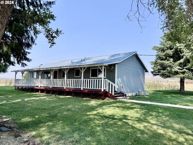 view of front of home featuring metal roof, a front lawn, and a porch