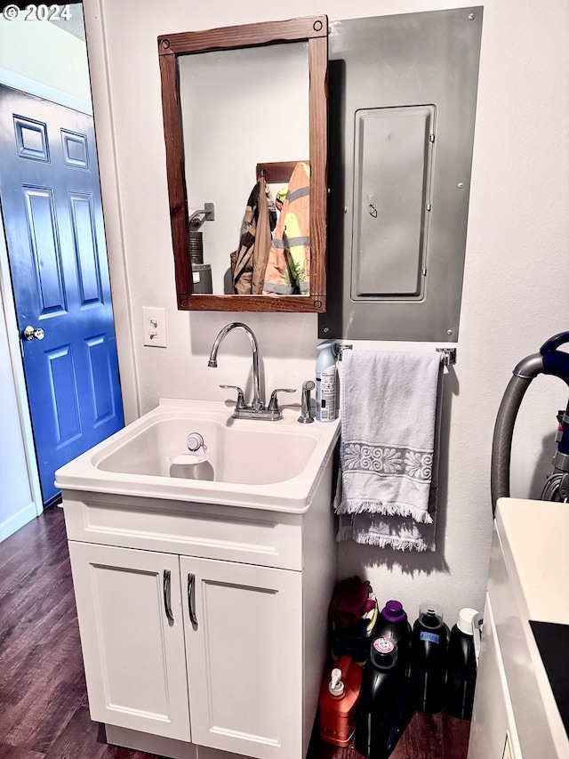 bathroom with electric panel, vanity, and wood finished floors