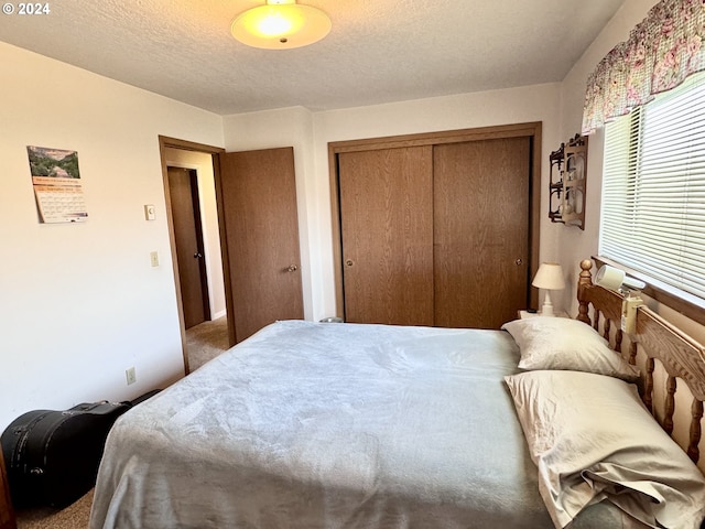 bedroom with a textured ceiling, a closet, and carpet