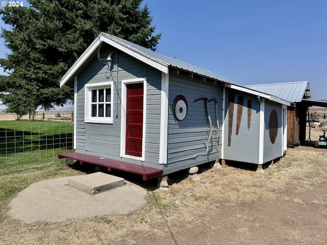 view of outbuilding featuring fence and an outdoor structure