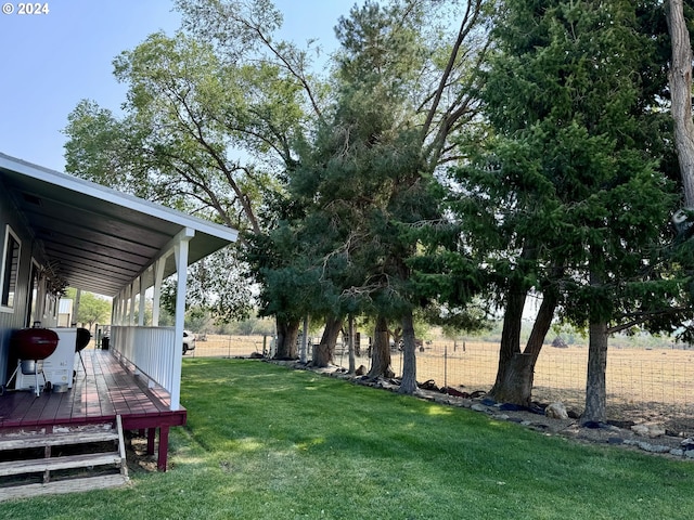 view of yard with a deck and fence