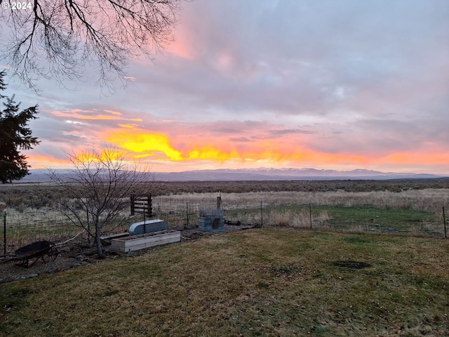 view of yard featuring fence, a mountain view, and a rural view