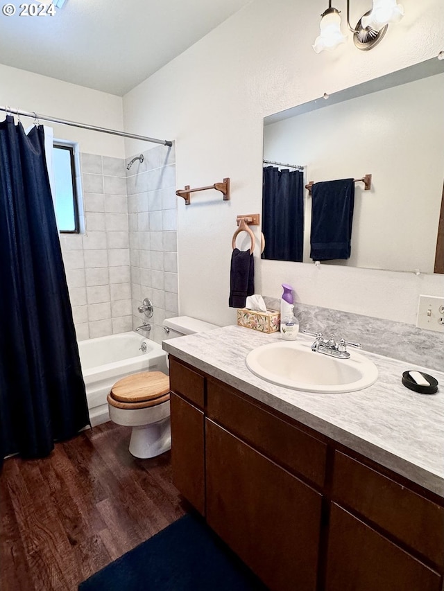 full bath with shower / bath combo, vanity, toilet, and wood finished floors