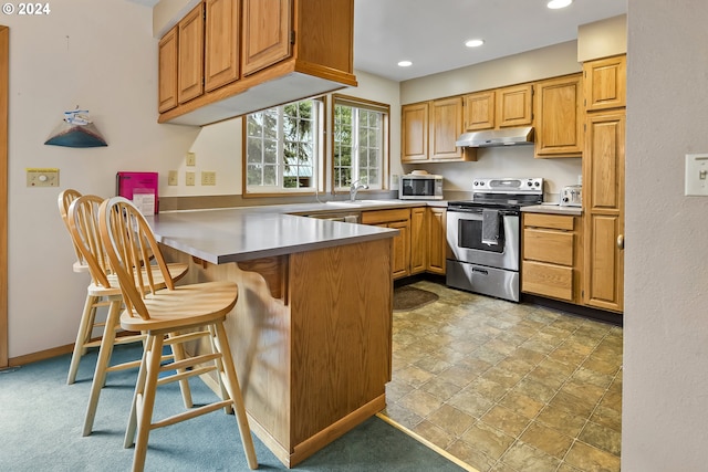 kitchen featuring a breakfast bar, kitchen peninsula, sink, and appliances with stainless steel finishes