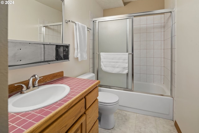 full bathroom with tile patterned floors, vanity, toilet, and bath / shower combo with glass door