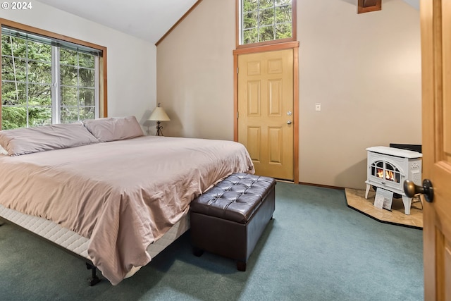 bedroom featuring carpet, vaulted ceiling, a wood stove, and multiple windows