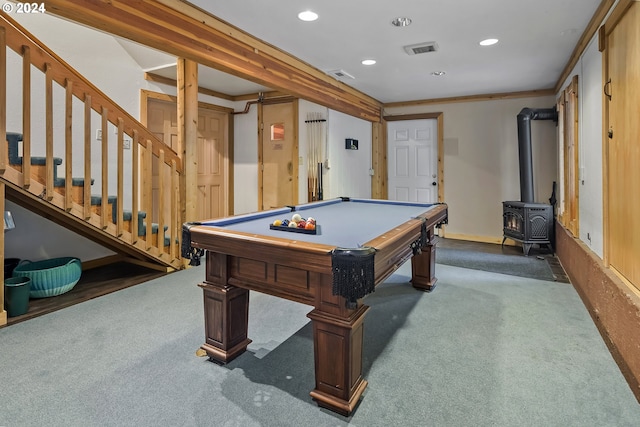 recreation room with dark colored carpet, a wood stove, ornamental molding, and pool table