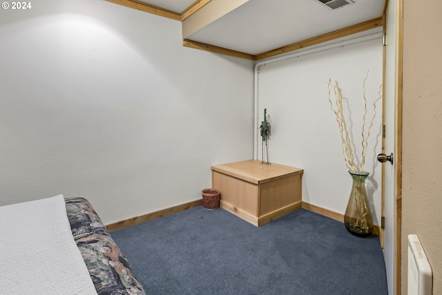 sitting room featuring dark carpet and radiator heating unit