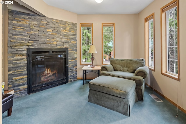 living area featuring a wealth of natural light, a fireplace, and carpet floors