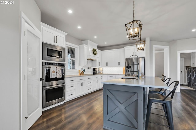 kitchen featuring white cabinetry, stainless steel appliances, dark hardwood / wood-style flooring, and pendant lighting