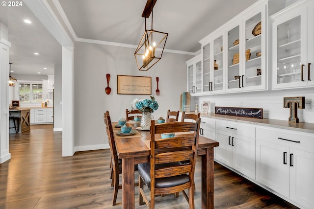 dining space with dark hardwood / wood-style flooring, an inviting chandelier, and crown molding