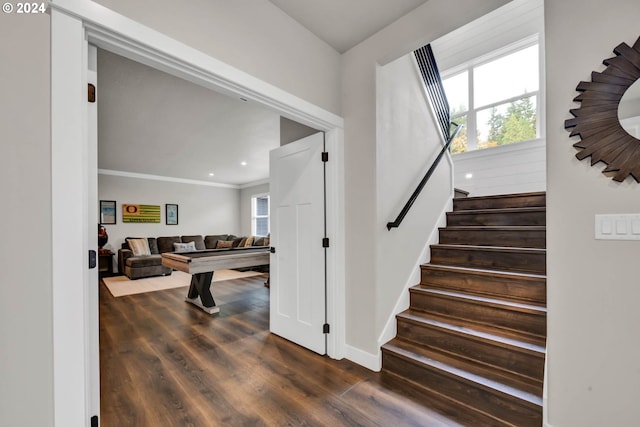 stairs with a wealth of natural light, hardwood / wood-style floors, and crown molding