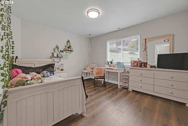 bedroom featuring dark wood-type flooring and a textured ceiling