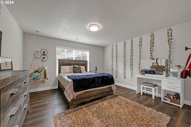 bedroom featuring dark hardwood / wood-style flooring and a textured ceiling