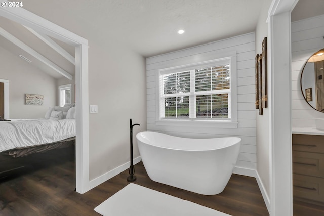 bathroom with vanity, a tub, wooden walls, hardwood / wood-style floors, and lofted ceiling