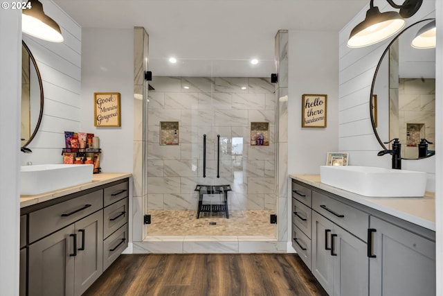 bathroom featuring wood walls, vanity, hardwood / wood-style flooring, and a shower with door