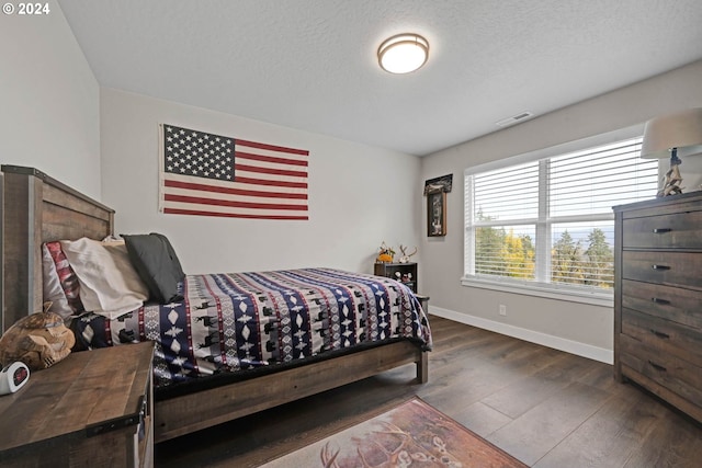 bedroom featuring dark hardwood / wood-style floors and a textured ceiling