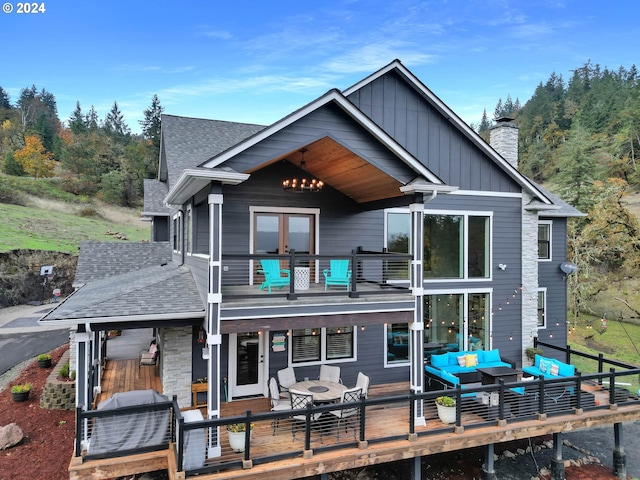 rear view of house featuring a deck and outdoor lounge area