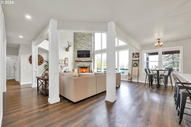 living room with a fireplace, plenty of natural light, dark hardwood / wood-style floors, and an inviting chandelier