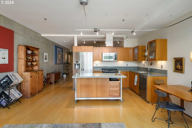 kitchen with sink, a center island, stainless steel appliances, and light hardwood / wood-style flooring