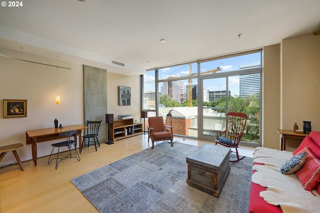 living room featuring wood-type flooring and a wall of windows