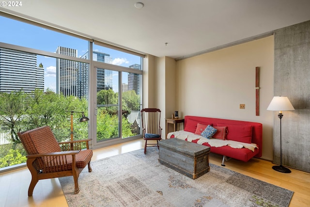 living room with expansive windows, a healthy amount of sunlight, and light hardwood / wood-style floors