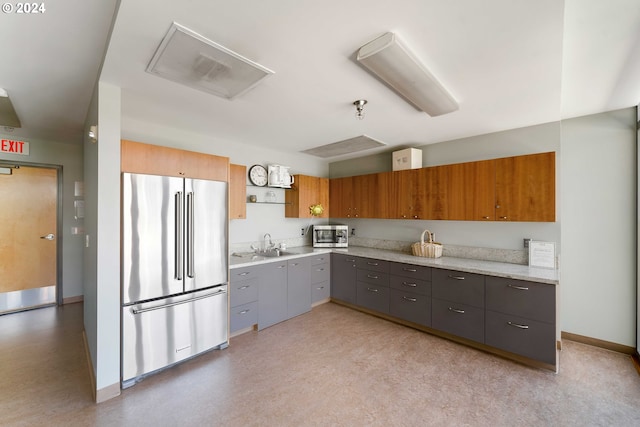 kitchen featuring light stone countertops, appliances with stainless steel finishes, gray cabinets, and sink