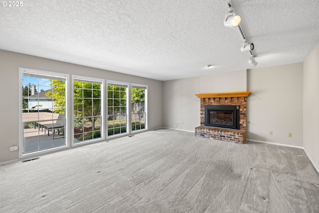 5393 SW Wichita St, Tualatin, OR 97062 - unfurnished living room featuring carpet flooring, rail lighting, a textured ceiling, baseboards, and a fireplace