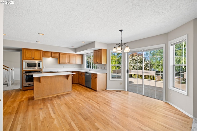 5393 SW Wichita St, Tualatin, OR 97062 - kitchen with appliances with stainless steel finishes, a textured ceiling, light wood-style flooring, light countertops, and a sink