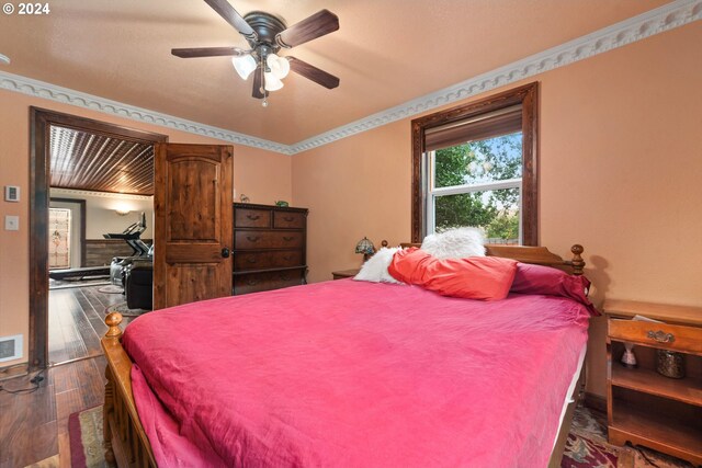 bedroom with ceiling fan, dark hardwood / wood-style floors, and ornamental molding