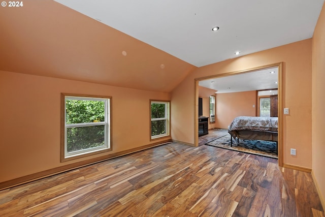 unfurnished bedroom featuring lofted ceiling and hardwood / wood-style floors