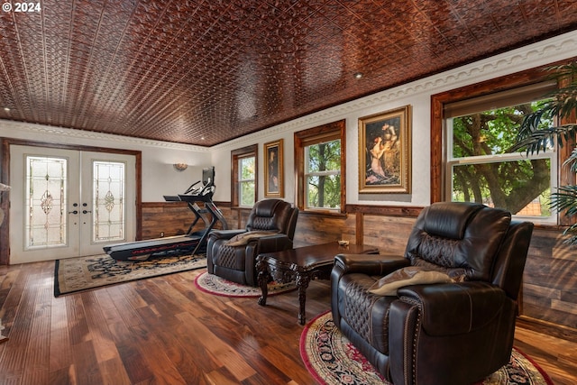 interior space featuring crown molding, wooden walls, wood-type flooring, and french doors