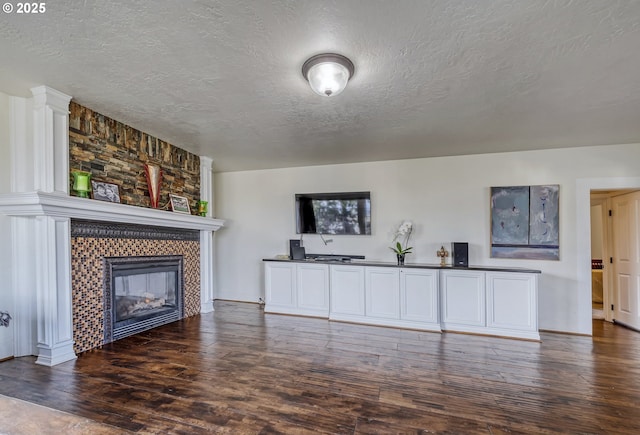 living area featuring wood-type flooring, a fireplace, and a textured ceiling