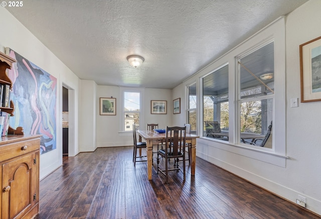 dining area featuring dark wood-style floors, a textured ceiling, and baseboards