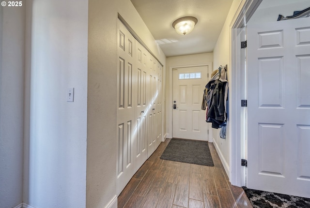 doorway to outside featuring dark wood-style floors and baseboards