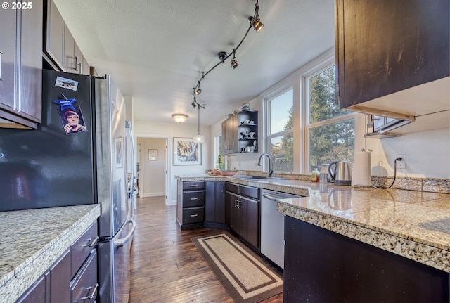 kitchen with tile countertops, stainless steel appliances, dark wood-type flooring, a sink, and a textured ceiling