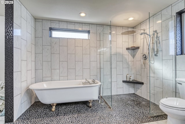 bathroom with a freestanding tub, toilet, tile walls, a tile shower, and tile patterned floors