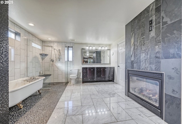 full bath featuring a tiled fireplace, toilet, marble finish floor, a walk in shower, and tile walls