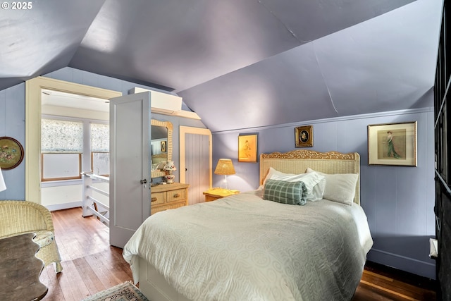 bedroom featuring hardwood / wood-style flooring and lofted ceiling